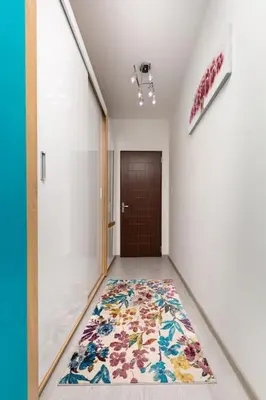 a hallway with a rug on the floor in front of a door at Comfy Apartment with Private Parking in Plovdiv