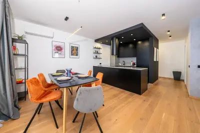 a kitchen and living room with a table and chairs at Vitosha Apartment With Parking in Sofia