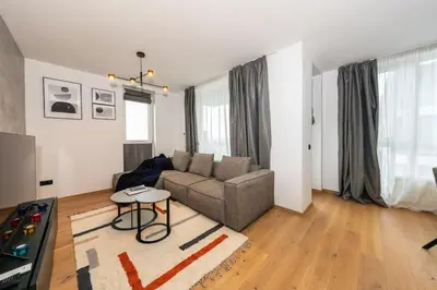 a living room with a couch and a table at Vitosha Apartment With Parking in Sofia
