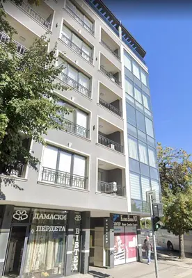 a tall white building on the corner of a street at Cozy 1-bed Apartment in Plovdiv