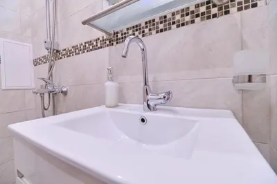 a white sink with a faucet in a bathroom at Cozy 1-bed Apartment in Plovdiv