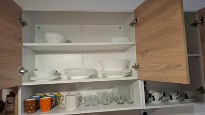 a kitchen cabinet with plates and cups and dishes at Apartment for rest in Borovets in Borovets