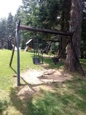 a swing set in a park next to a tree at Apartment for rest in Borovets in Borovets