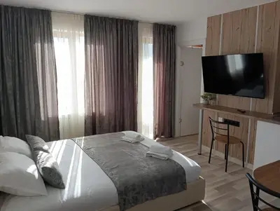 a hotel room with a bed and a flat screen tv at Monfort A in Bansko