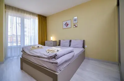 a bedroom with a large bed and a window at Cozy 1-bed Apartment 2 in Plovdiv