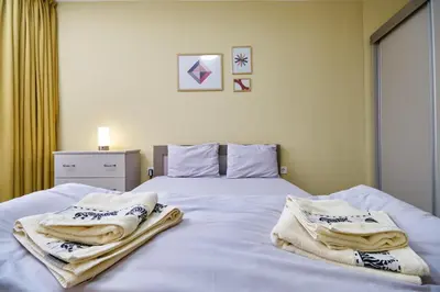 a bedroom with a bed with towels on it at Cozy 1-bed Apartment 2 in Plovdiv