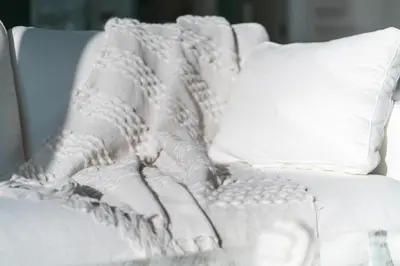 a white couch with a blanket and pillows at Emirates White Sensation in Sofia