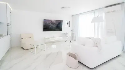 a white living room with a white couch and a table at Emirates White Sensation in Sofia