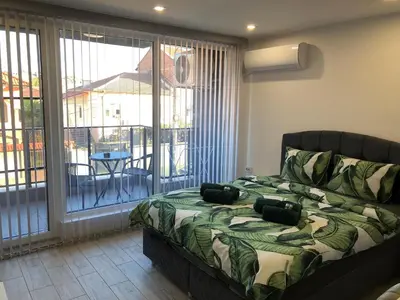 a bedroom with a bed and a balcony with a table at Ultra Lux Studio Free Underground Secure Parking in Pazardzhik