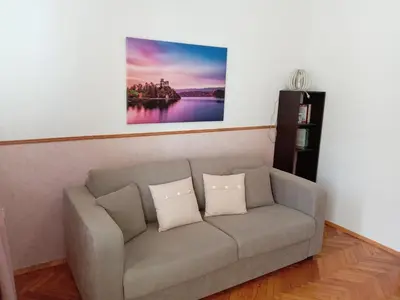 a living room with a couch with two pillows at Sofia Center Chic Suite - Separate Kitchen and Balcony in Sofia