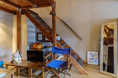a room with a staircase with blue chairs and a mirror at The Gallery - Art Studio in the Heart of Sofia by Flat Mаnager in Sofia