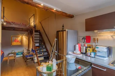 a kitchen with a stainless steel refrigerator and a staircase at The Gallery - Art Studio in the Heart of Sofia by Flat Mаnager in Sofia