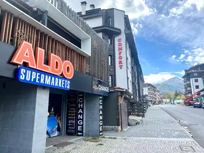 a building with an aloda supermarket sign on a street at Private Suite at Comfort Bansko in Bansko