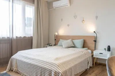 a bedroom with a bed with a white bedspread at Your Place in Sofia