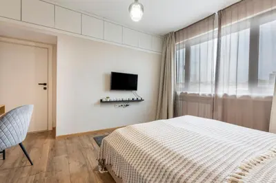 a bedroom with a bed and a tv and a window at Your Place in Sofia