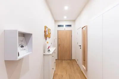 a bathroom with white walls and a wooden door at Your Place in Sofia