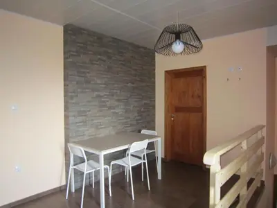 a dining room with a table and chairs and a brick wall at Slavina Guest House in Sapareva Banya