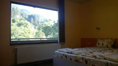 a bedroom with a bed and a large window at Slavina Guest House in Sapareva Banya