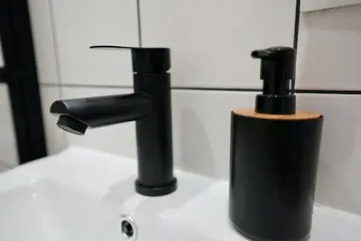 a bathroom sink with a black faucet at Lily's Studio 4 by Bulgarentals - Central Sofia in Sofia