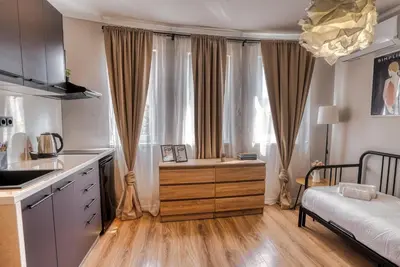 a kitchen with a bed and a desk in front of a window at Lily's Studio 4 by Bulgarentals - Central Sofia in Sofia