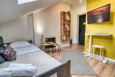 a bedroom with a bed and a tv on a wall at Lily's Studio 6 by Bulgarentals - Central Sofia in Sofia