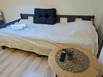 a bed with a table with a remote control on it at Lily's Studio 6 by Bulgarentals - Central Sofia in Sofia