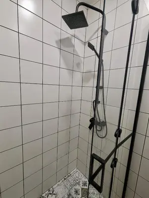 a shower in a white tiled bathroom at Lily's Studio 6 by Bulgarentals - Central Sofia in Sofia