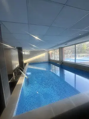 a large swimming pool in a building at Хотел Костенец in Kostenets Village