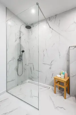 a bathroom with a shower with white marble walls at Bright and Stylish 2BD Flat in The City Centre by Flat Mаnager in Sofia