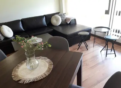 a living room with a vase with flowers on a table at Apartament by Zenit in Terra Complex B30 in Razlog