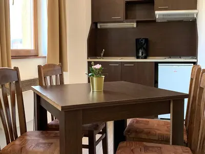 a kitchen with a wooden table with a vase on it at Banderitsa Studio Bansko 2 in Bansko