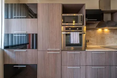 a kitchen with wooden cabinets and a microwave at Deja vu, Cozy & Quiet 1 BDR Apt Fast Wi-Fi in Sofia