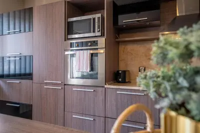 a kitchen with wooden cabinets and a microwave at Deja vu, Cozy & Quiet 1 BDR Apt Fast Wi-Fi in Sofia