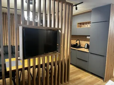 a large flat screen tv on a wall in a kitchen at Avelov Art Studio in Pamporovo