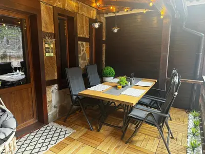 a wooden table and chairs on a patio at Avelov Art Studio in Pamporovo