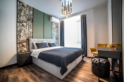a bedroom with a bed and a desk and a window at ARHEYA 1 apart Архея 1 апартамент за гости in Karlovo