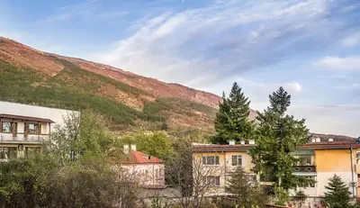 a group of buildings in front of a mountain at ARHEYA 1 apart Архея 1 апартамент за гости in Karlovo