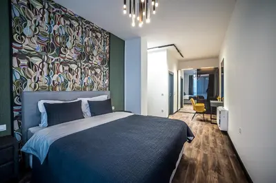 a bedroom with a large bed with a colorful wall at ARHEYA 1 apart Архея 1 апартамент за гости in Karlovo