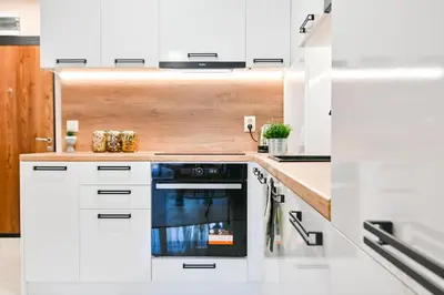 a kitchen with white cabinets and a black oven at Armand de Azurro in Sofia
