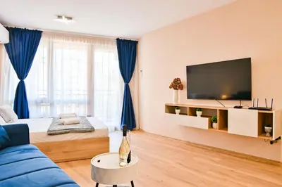 a living room with a blue couch and a tv at Armand de Azurro in Sofia