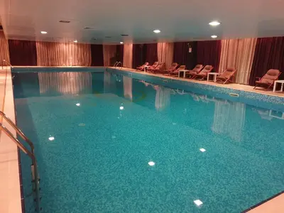 a large swimming pool with chairs in a hotel at апартаменти Уют Гранд Манастира in Pamporovo