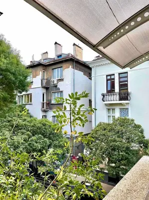 a view of a building from a balcony with trees at Heart of the city in Sofia