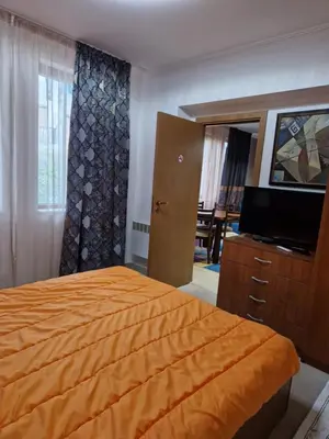 a bedroom with a bed and a dresser and a television at Snow Mountain Grand Monastery in Pamporovo