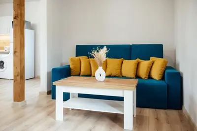 a blue couch with yellow pillows and a table at VILLA MEDI boutique in Sapareva Banya