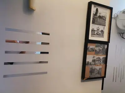 a wall with two pictures and a mirror on it at Sky-view apartmentin perfect city center Sofia in Sofia
