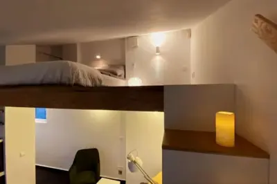 a bedroom with a bed and a desk with a lamp at Sky-view apartmentin perfect city center Sofia in Sofia