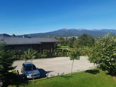 a car parked in a parking lot in front of a building at Pirin Golf Guest Room in Razlog