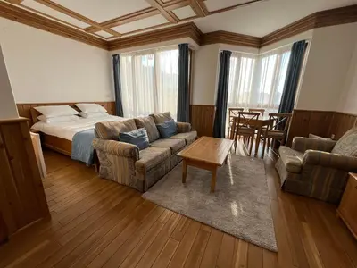 a bedroom with a bed and a couch and a table at Pirin Golf Guest Room in Razlog
