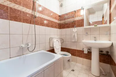 a bathroom with a toilet and a sink and a bath tub at Penthouse Tepeto in Plovdiv