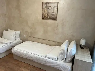 a bedroom with two beds and a painting on the wall at Апартамент Комфорт 2 Близо до Летището in Sofia